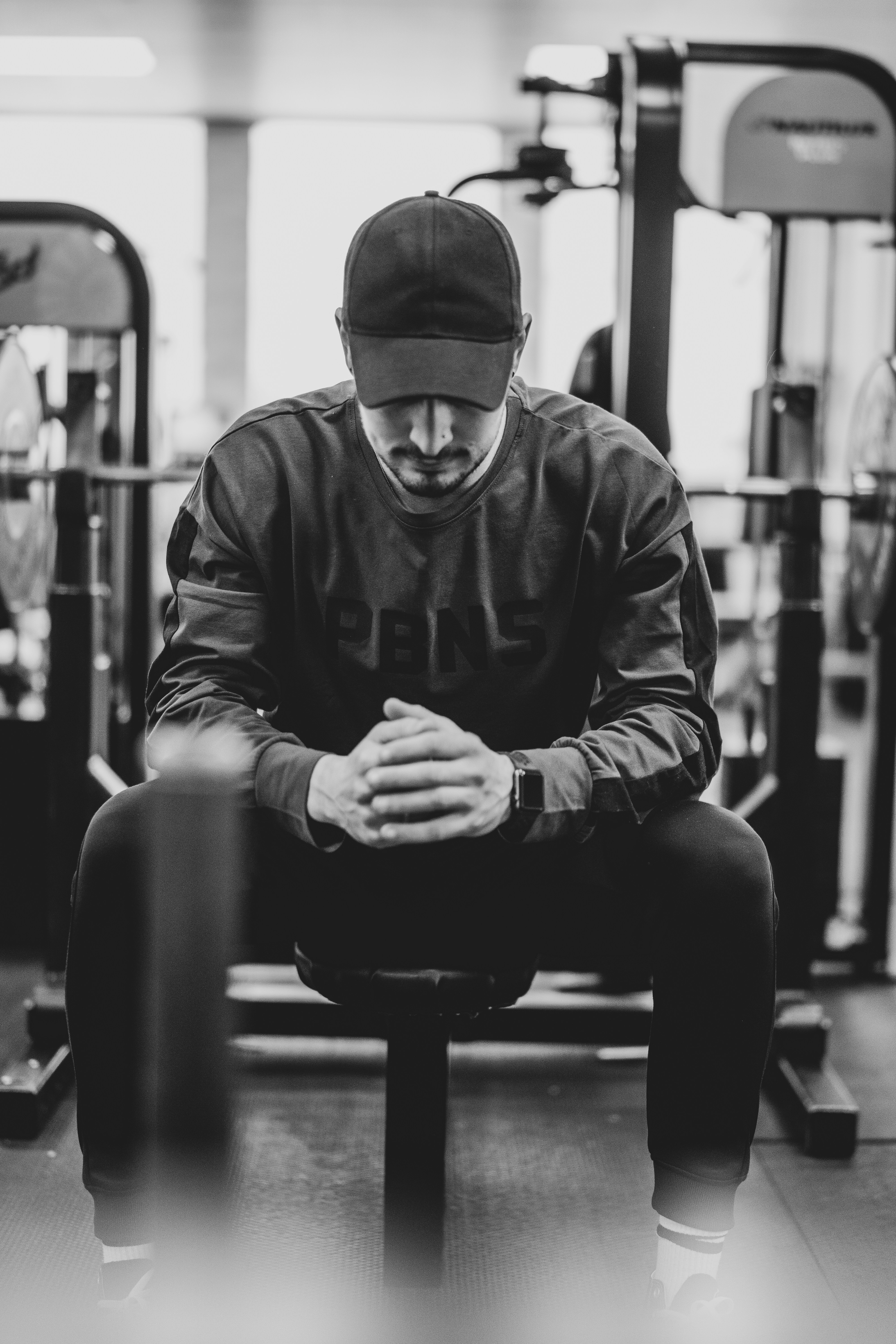 An athlete checking their Apple Watch mid-workout in a dim home gym.