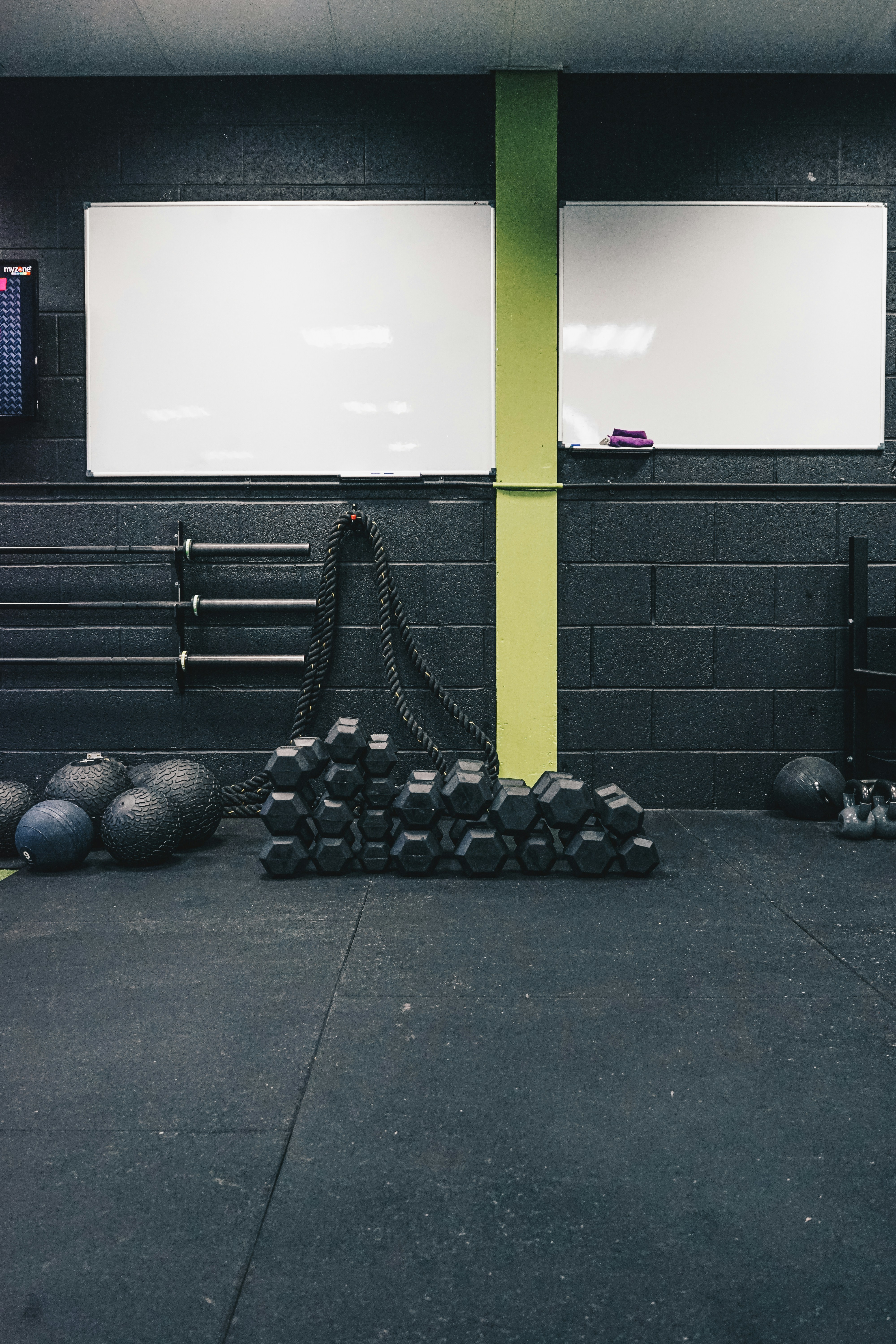 A functional fitness gym whiteboard with the day's WOD chalked out.